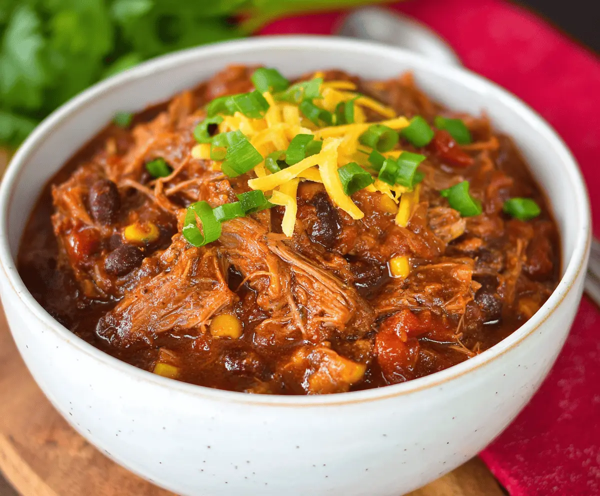 Deliciously cooked pork roast chili served in a bowl with fresh toppings, perfect for a hearty meal.