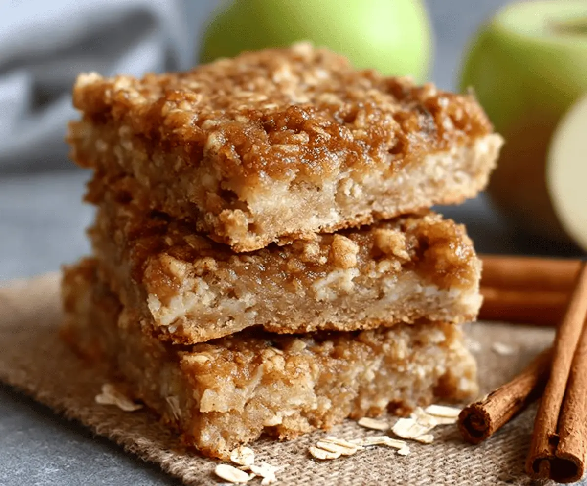 Delicious chewy apple cinnamon oatmeal bars with a golden crust and cinnamon-spiced apple filling, perfect for a tasty breakfast or snack.