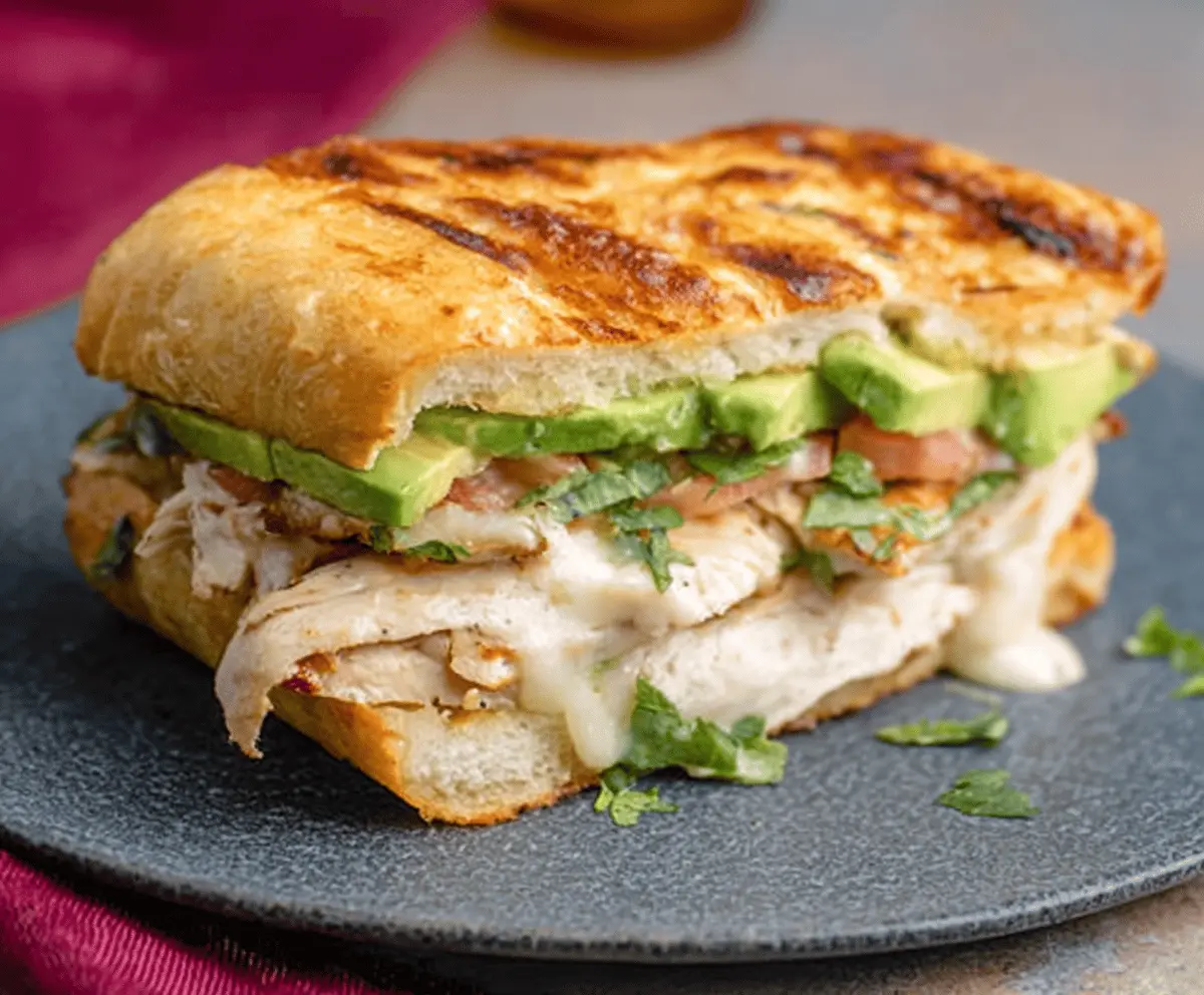 Delicious Chicken Avocado Melt Sandwich with melted cheese and fresh avocado slices.