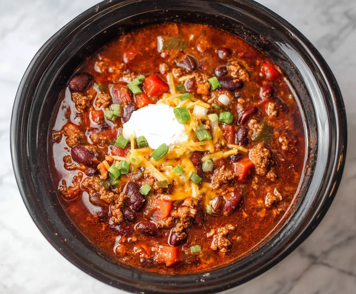 Hearty Crockpot Root Beer Chili in a bowl with toppings, perfect for a comforting meal